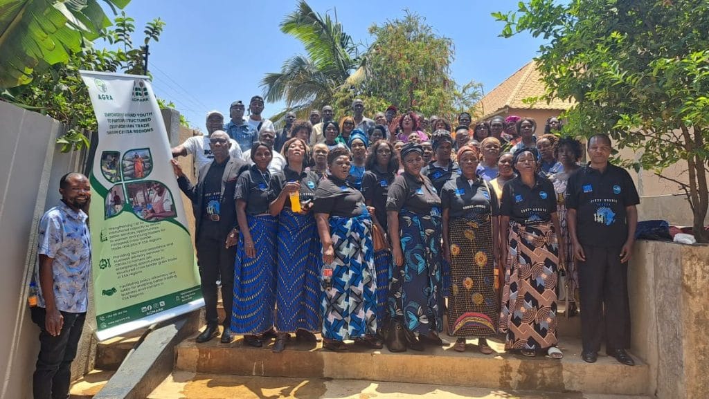 Large group of women in Nakonde, Zambia, for women's training, dressed in black shirts with blue accents, focusing on cross-border grain trade